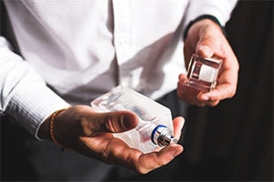 man holds a cologne bottle in his hands