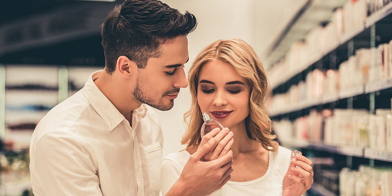 A man and woman both testing the scent of an eau de toilette fragrance.